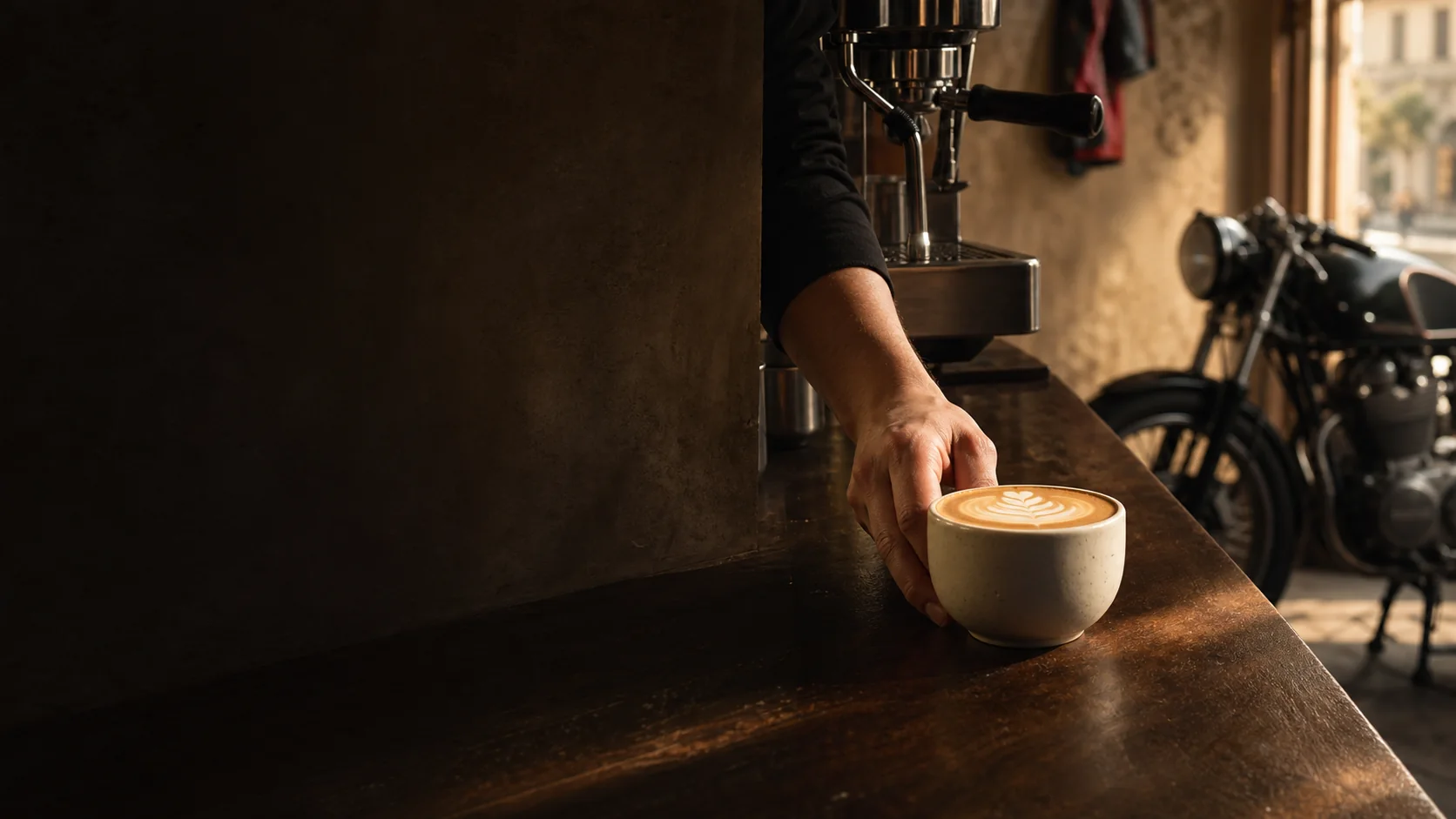 Cappuccino served at a warm coffee bar with a café-racer motorcycle nearby